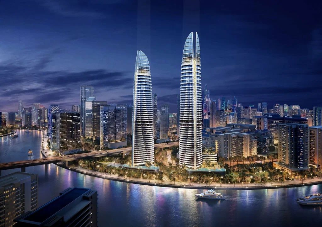 Sobha Seahaven twin towers at Dubai Harbour waterfront at night &mdash; benefits of buying property in Dubai for Indian investors